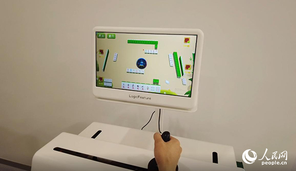 工作人員正在演示“運(yùn)動(dòng)-認(rèn)知康復(fù)機(jī)器人”。人民網(wǎng)記者 郝帥攝